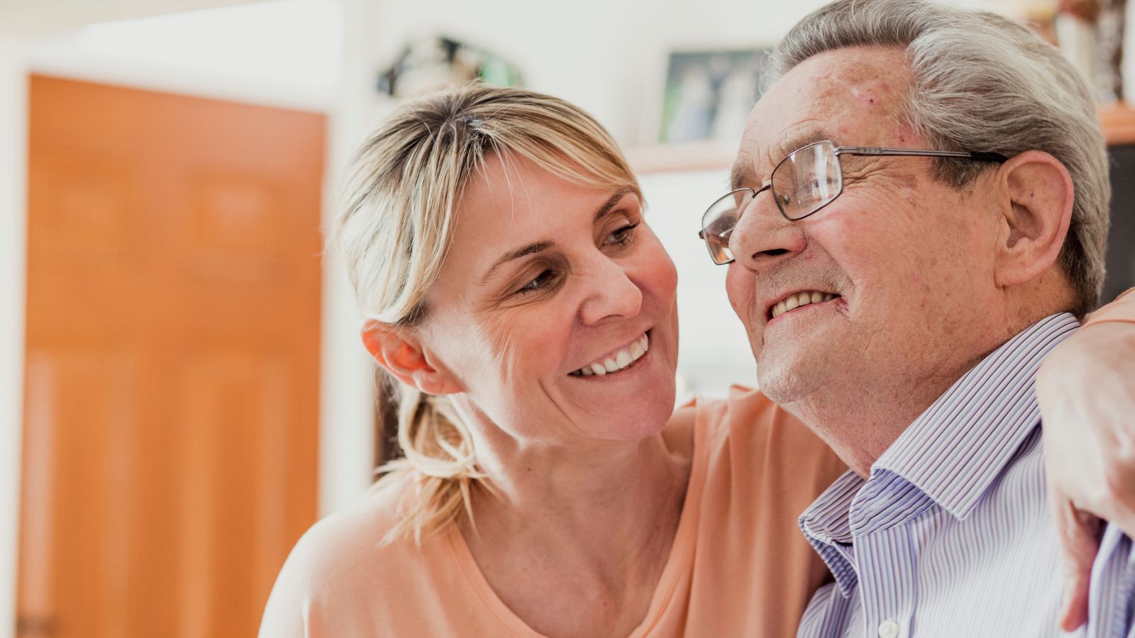Smiling woman with arm around elderly man