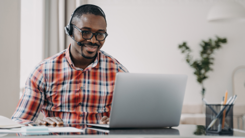 Man sitting at laptop smiling